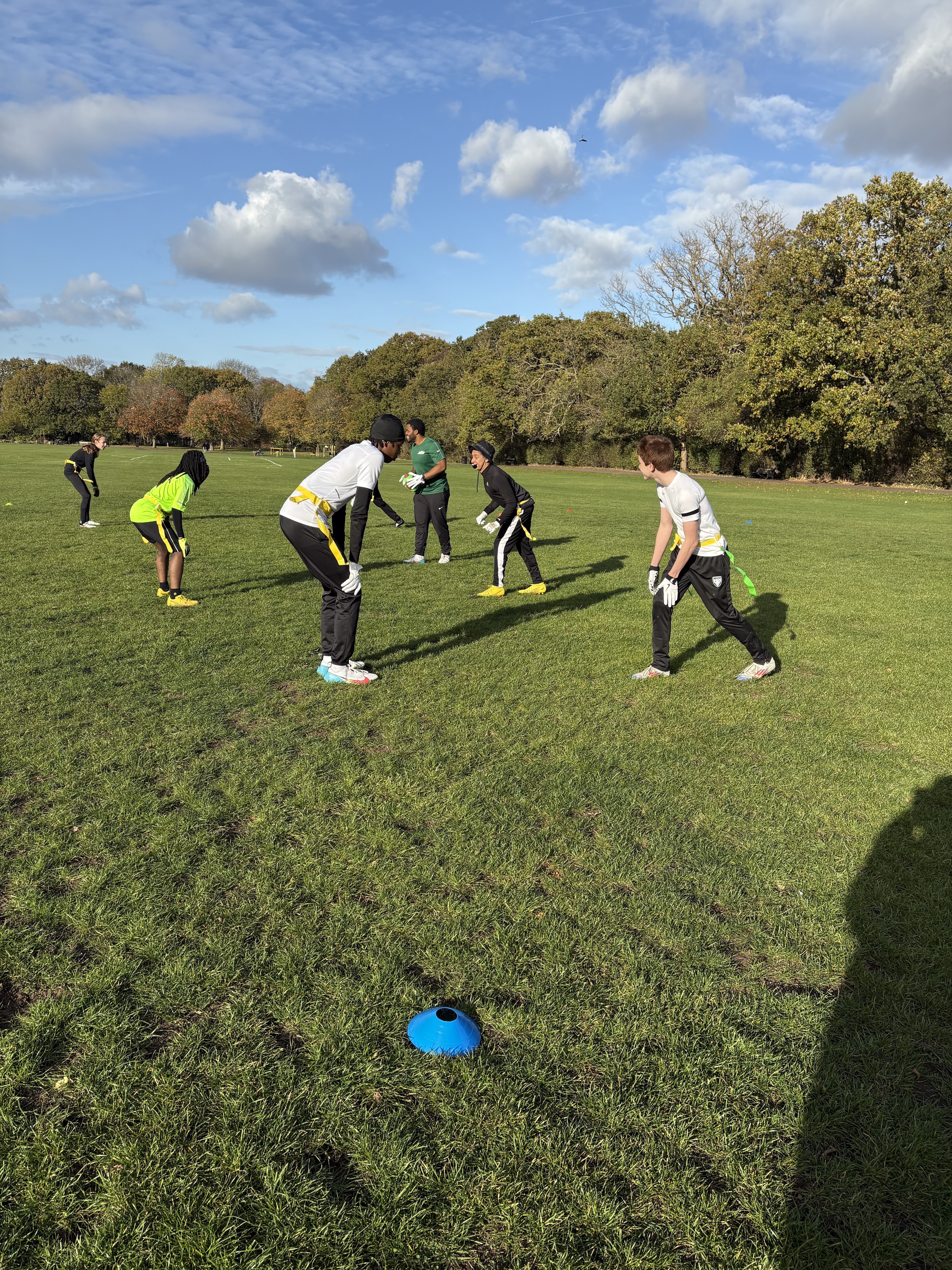 Children taking part in flag football on a grass field